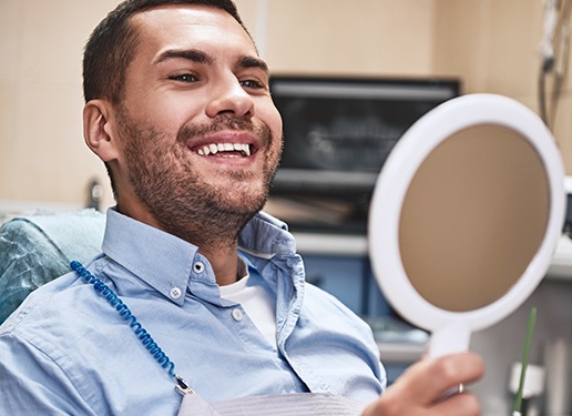 man smiling in circle mirror