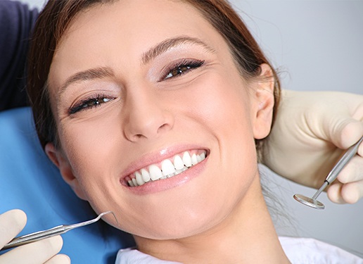 woman sitting in exam chair smiling at camera