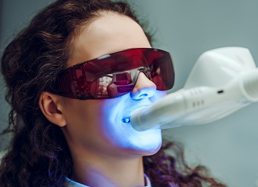 woman with protective glasses on getting teeth whitening