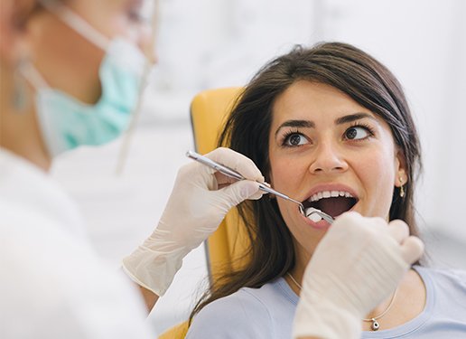 woman looking at dentist while getting a checkup